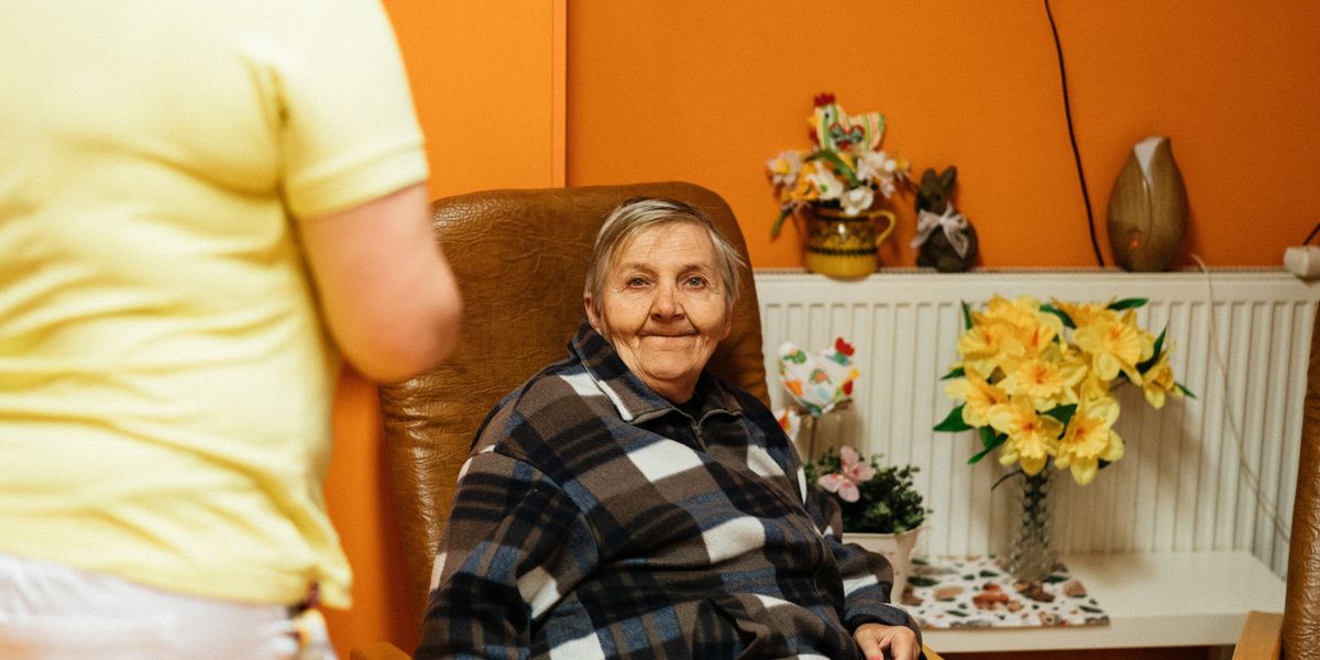 A senior woman in a care-home armchair
