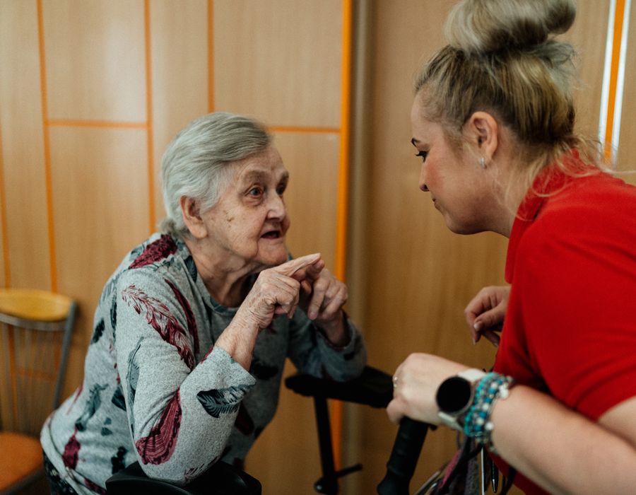 A caregiver in conversation with an elderly resident